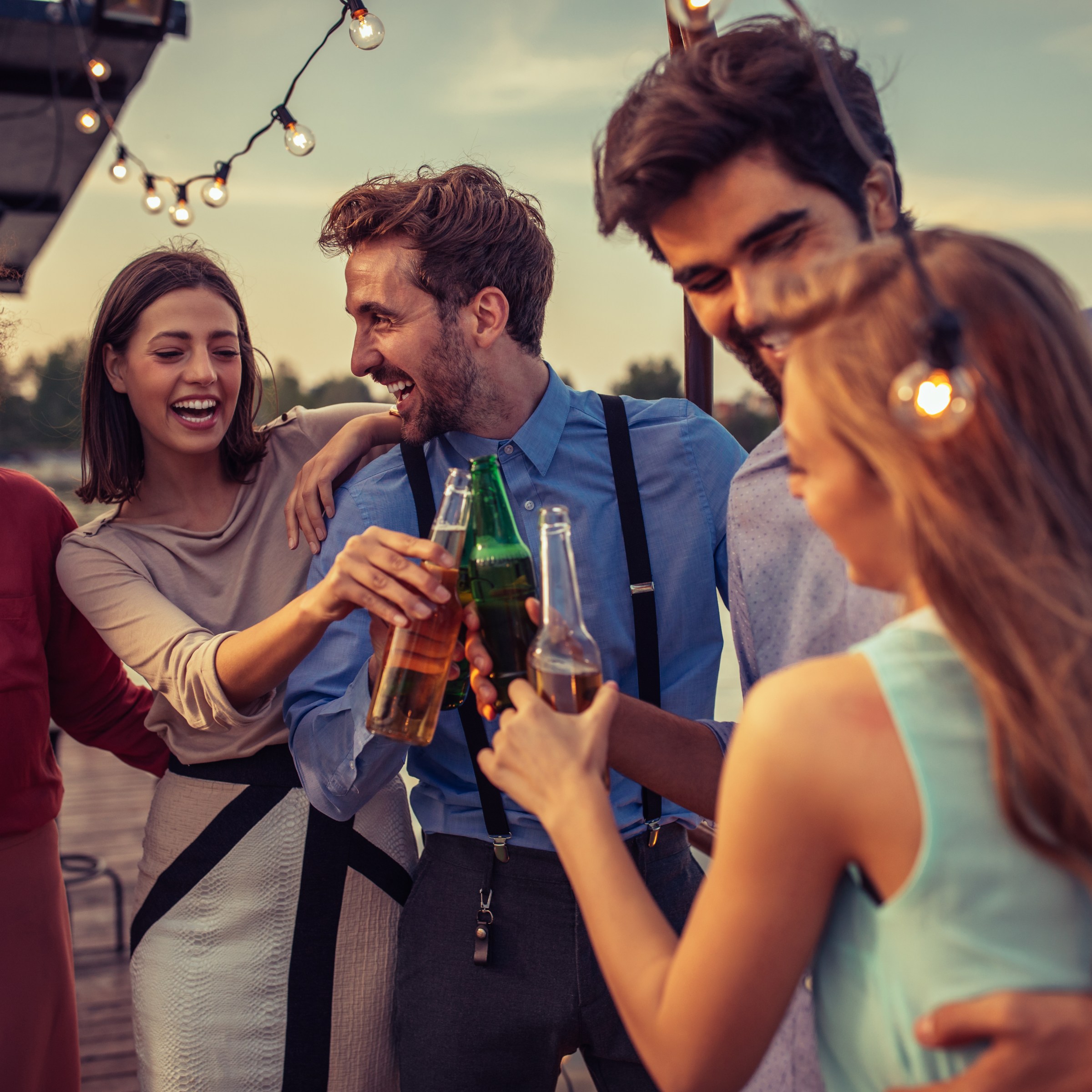 Group of friends cheering with drinks on a boat cruise