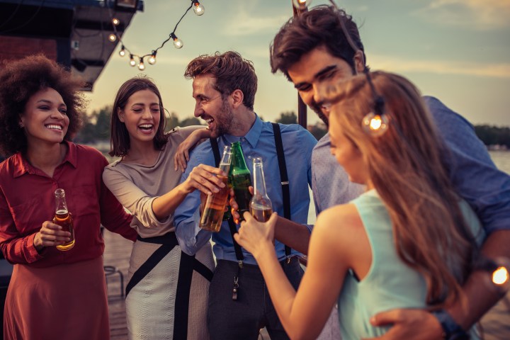 Group of friends cheering with drinks on a boat cruise
