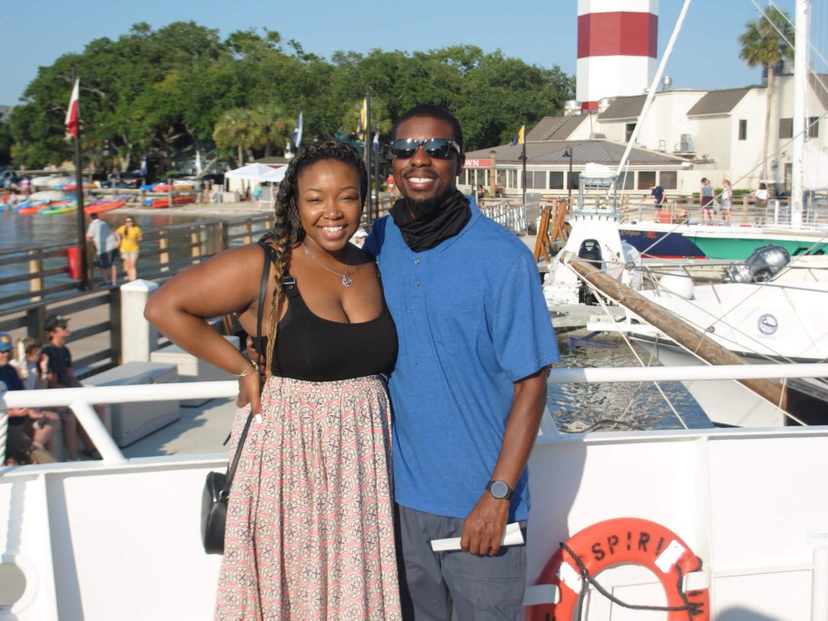 a man and a woman standing next to a boat
