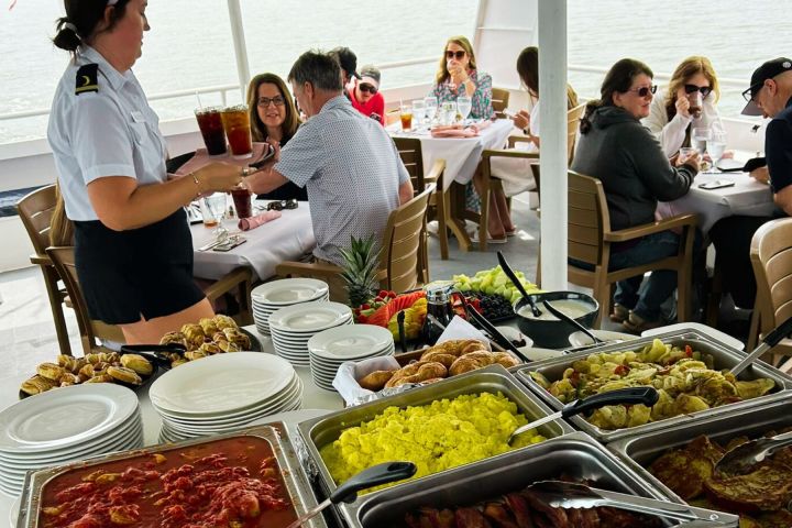 a group of people sitting at a table full of food