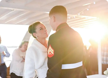 Bride and groom dancing under a sunlit canopy.
